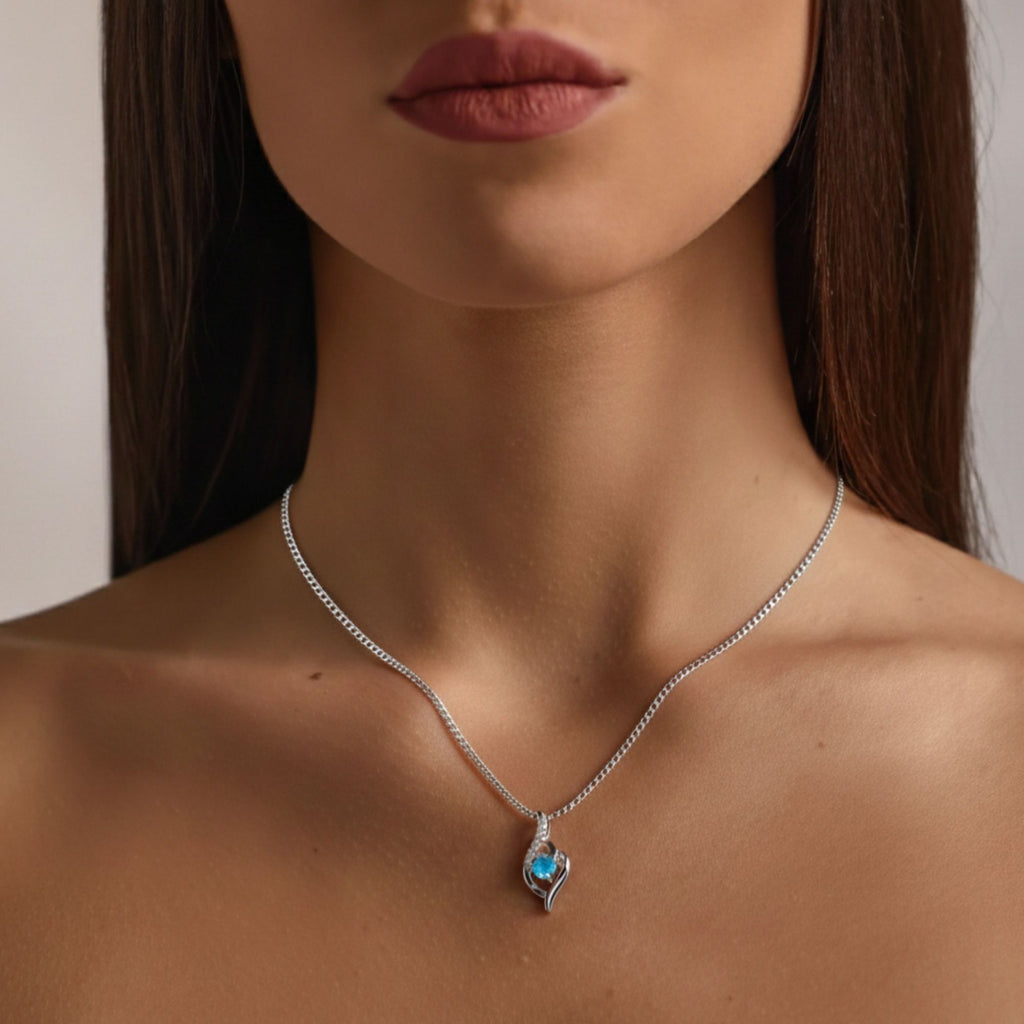 Modelo usando o colar Cristal Aurora prateado com cristal azul e corrente fina
