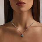 Modelo usando o colar Cristal Aurora prateado com cristal azul e corrente fina