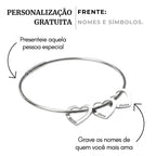 Bracelete_prateado_rigido_com_pingentes_de_coracao_personalizados_com_nomes_gravados_design_minimalista_e_delicado