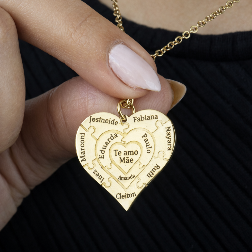 Colar_Coracao_de_Mae_dourado_personalizado_com_nomes_gravados_modelo_segurando_o_pingente_para_destacar_os_detalhes