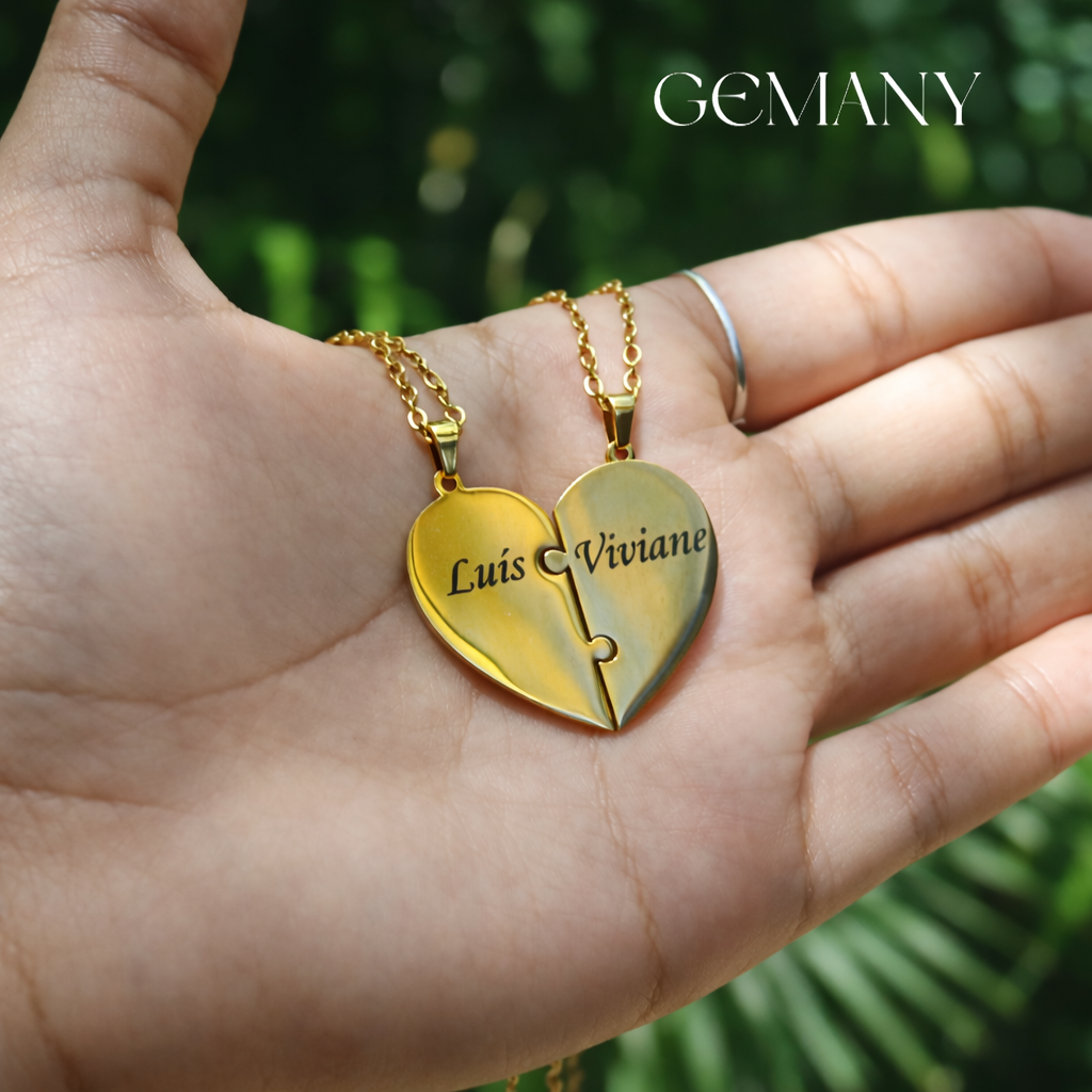 Colar dourado em formato de coração de quebra-cabeça com os nomes Luis e Viviane apoiado na palma de uma mão