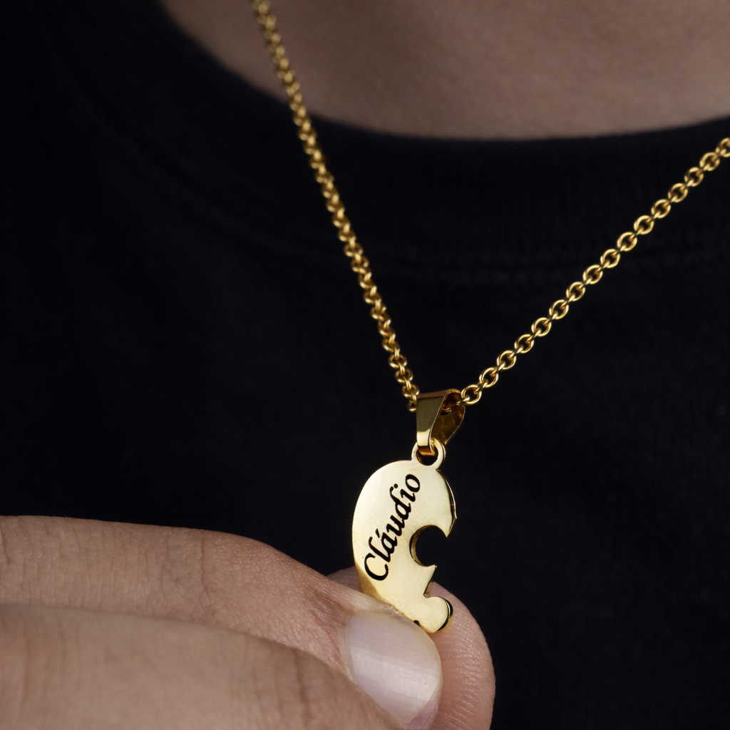 pingente de colar quebra-cabeça dourado com nome gravado sendo segurado pela mão