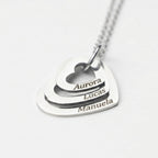 Colar_Coracoes_Crescentes_prateado_personalizado_com_nomes_modelo_segurando_o_pingente_para_destacar_os_detalhes_da_gravacao