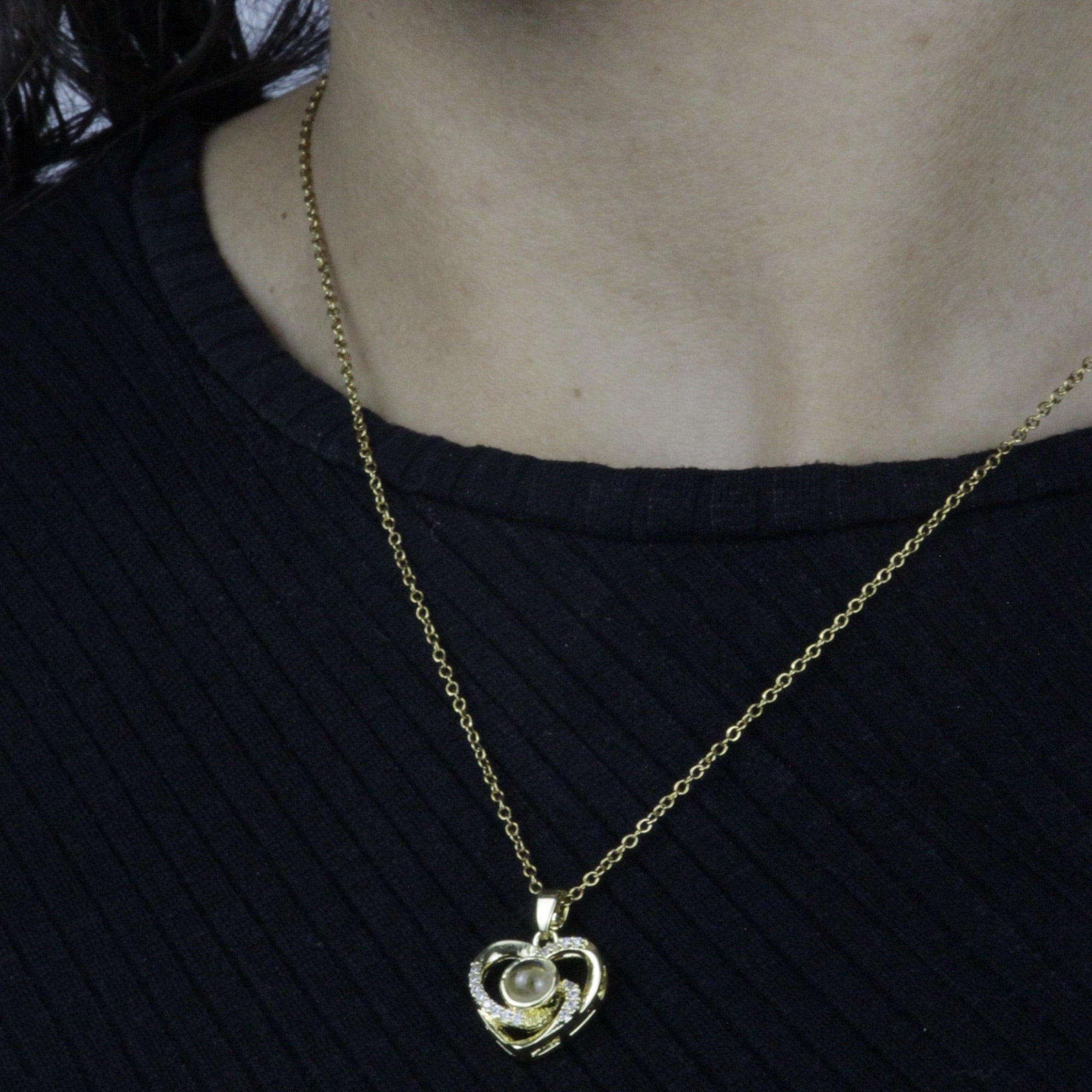 Colar_Eu_te_amo_dourado_sendo_usado_no_pescoco_com_pingente_coracao_e_pedra_central_delicada