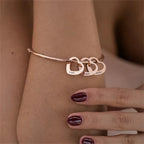 pulseira rígida personalizada rosé com pingentes de coração gravados usada no pulso
