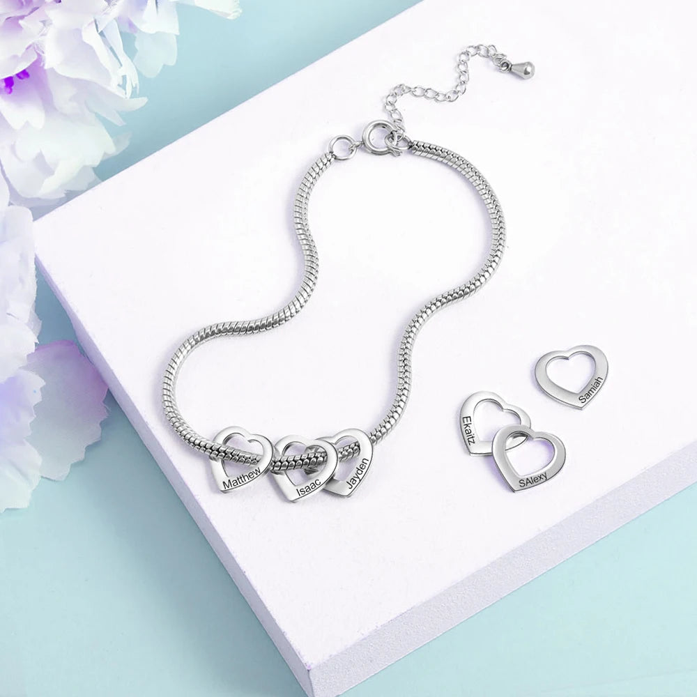 pulseira flexível personalizada prateada com pingentes de coração removíveis gravados com nomes