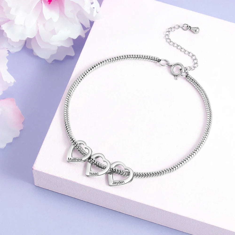 pulseira flexível personalizada prateada com três pingentes de coração gravados