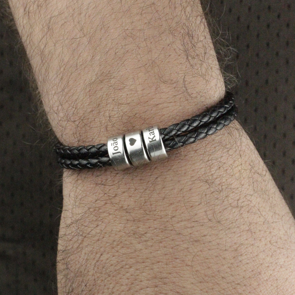 Pulseira_masculina_preta_com_gravacao_de_nomes_e_simbolo_de_coracao_vista_em_angulo_lateral