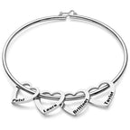 pulseira rígida personalizada prateada com pingentes de coração gravados com nomes