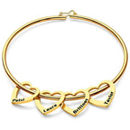 pulseira rígida personalizada dourada com quatro pingentes de coração gravados com nomes