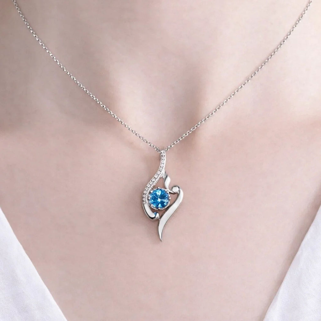 Colar Cristal Aurora prateado com cristal azul no colo de uma mulher