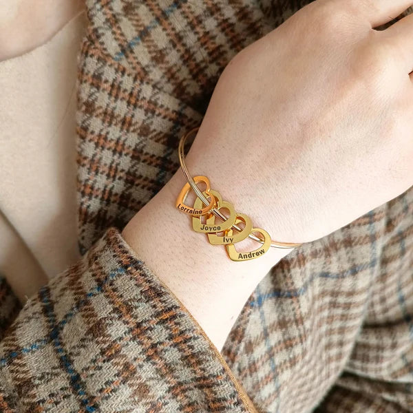 pulseira rígida personalizada dourada com vários pingentes de coração gravados